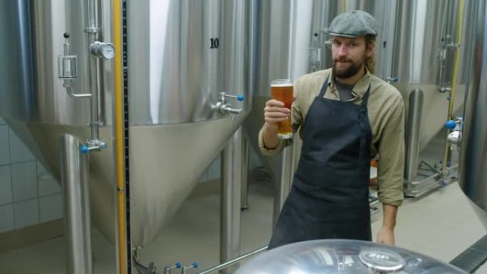 年轻的精酿啤酒厂老板与一品脱啤酒合影的肖像