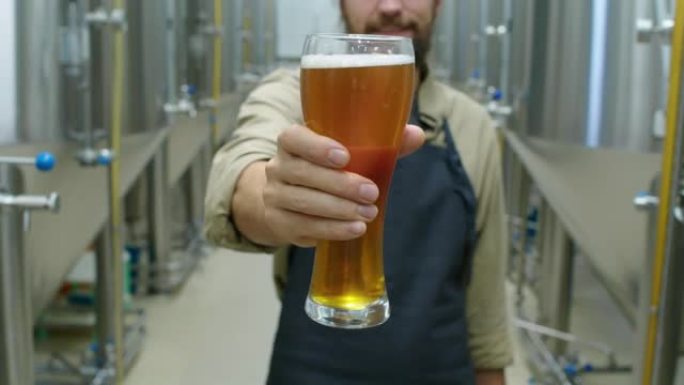 匿名酿酒师在啤酒厂展示一品脱新鲜啤酒