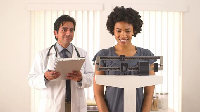 非裔美国妇女与医生一起检查体重