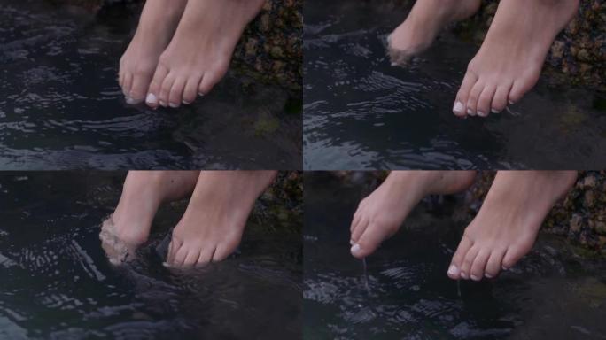特写女人的脚在水中嬉戏赤脚享受平静的海滩海边