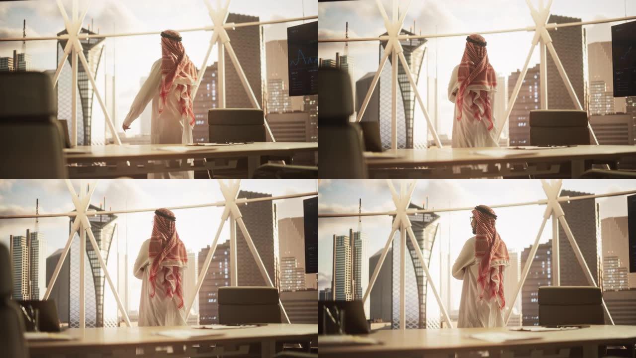 穿着传统白色服装的成功穆斯林商人走进他现代的办公室，看着窗外的摩天大楼。成功的沙特，阿联酋，阿拉伯商