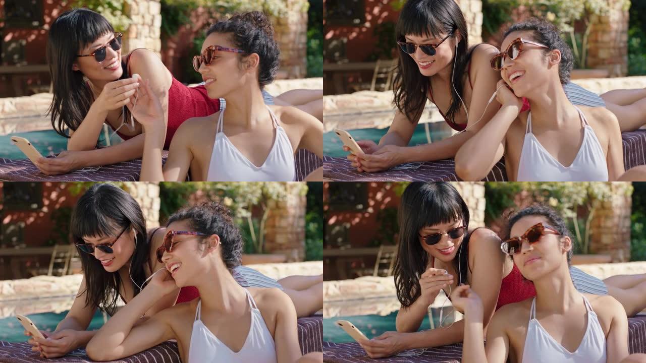 两个美丽的女人在游泳池边放松听音乐女孩朋友享受夏日放松在温暖阳光明媚的日子里晒日光浴假期生活方式4k