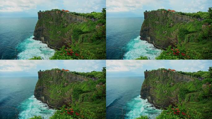 原始的热带绿色海滩，乌鲁瓦图神庙Pura Luhur印度教在巨大的悬崖深渊和巴厘岛无尽的海洋地平线上