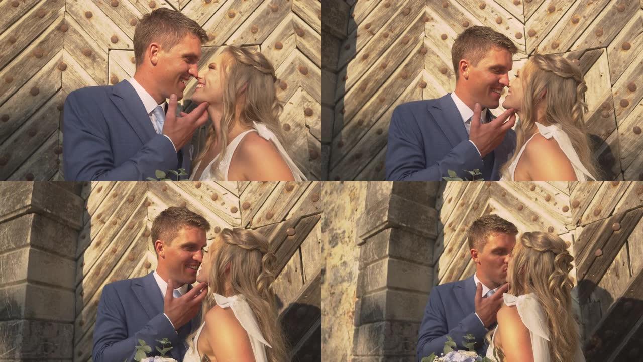 亲密相爱的新婚夫妇在大木门前分享浪漫的吻