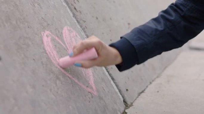年轻女子手绘心用粉色粉笔快乐少女恋爱情人节概念