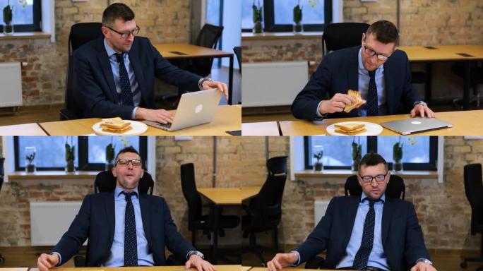 实时视频。高加索人正在研究他的笔记本电脑和咬三明治。男人看起来很饿，他大口大口。男性正在享受食物，看