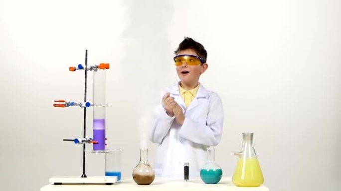 穿着制服的小男孩化学家，防护眼镜在白色背景上成功测试了新配方，获得了快乐和奇迹