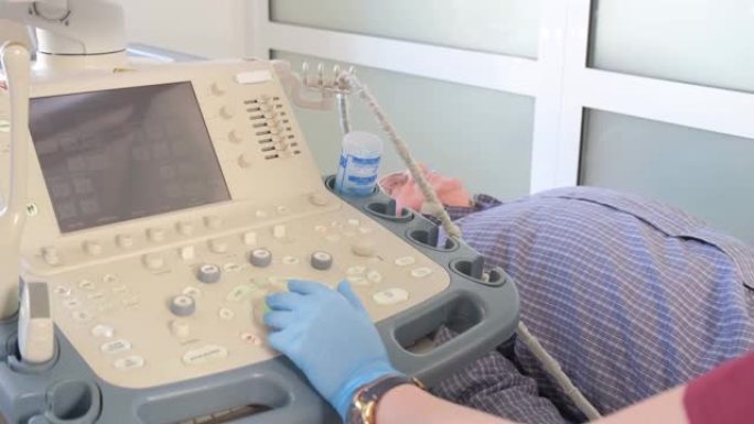 一位医生在诊所为一位老年病人的腿部关节做超声波检查。4 k的视频