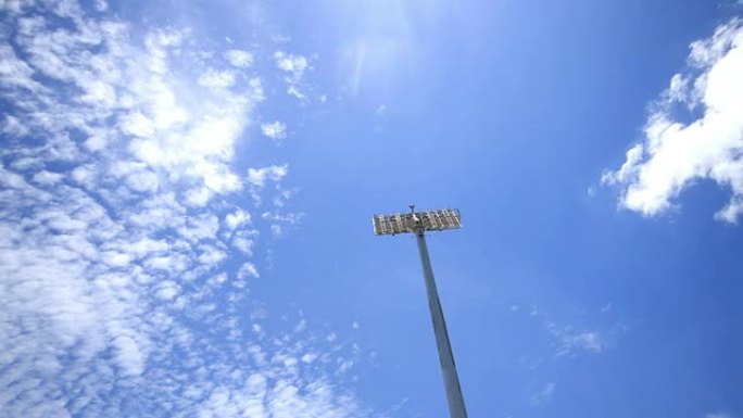 体育场聚光灯，美丽的蓝天和云运行背景，时间流逝。