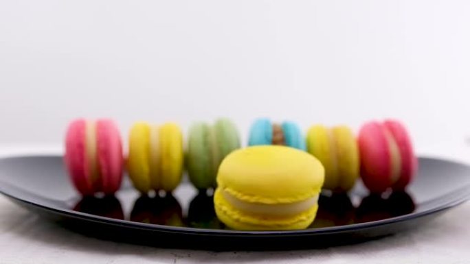 甜马卡龙旋转黄色背景面包店食品颜色糖珍珠法国甜点美味餐桌马卡龙慢动作