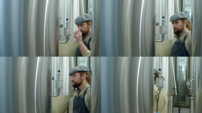 男性啤酒厂员工检查发酵罐上的压力表