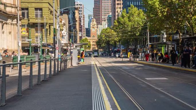 澳大利亚维多利亚州墨尔本市布尔克街和伊丽莎白街附近弗林德斯街火车站拥挤的通勤者和游客步行和过马路的时