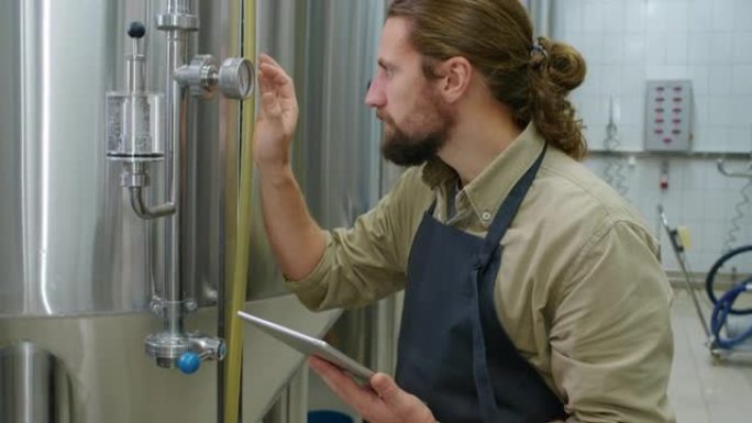 高加索酿酒师检查啤酒厂的控制仪表