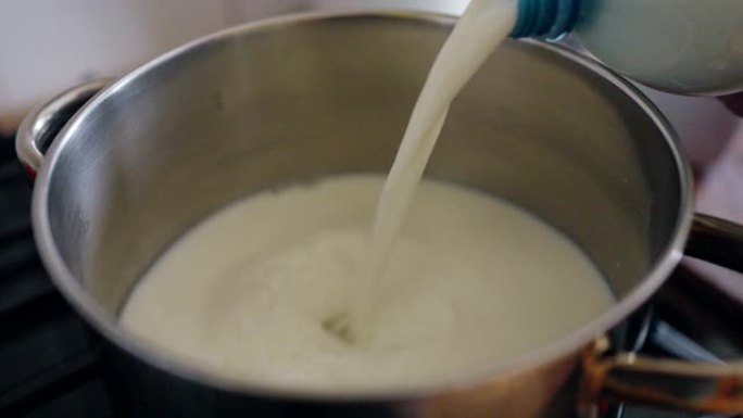 将水罐中的牛奶倒入平底锅中