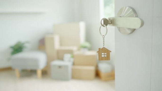 搬家，搬迁。钥匙插在新房子的门上，房间里是一个纸箱，里面装有个人物品和家具。搬进公寓或公寓