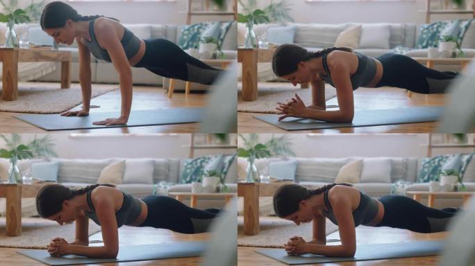 健康的年轻女子在家锻炼，在客厅练习木板，享受早晨健身锻炼4k