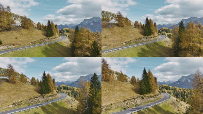 秋天在阿尔卑斯山的道路上骑自行车的两个人的鸟瞰图