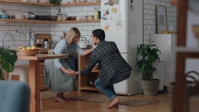 快乐的年轻夫妇在厨房跳舞，庆祝一起跳舞，享受有趣的浪漫关系，在家4k镜头
