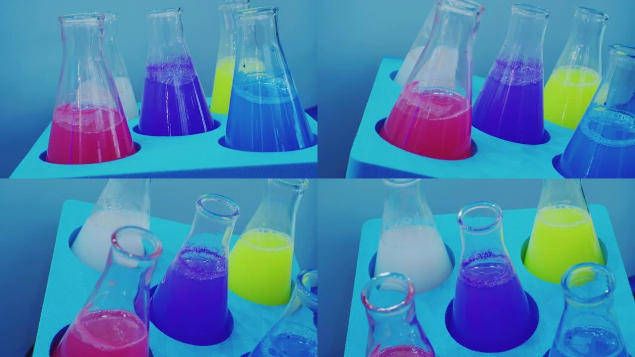 化学实验室。将不同颜色的彩色液体倒入摇床中的试管旋转。