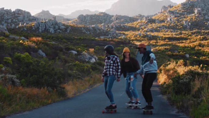 快乐的多民族朋友一起骑滑板在乡村路上巡航玩得开心，享受轻松的暑假