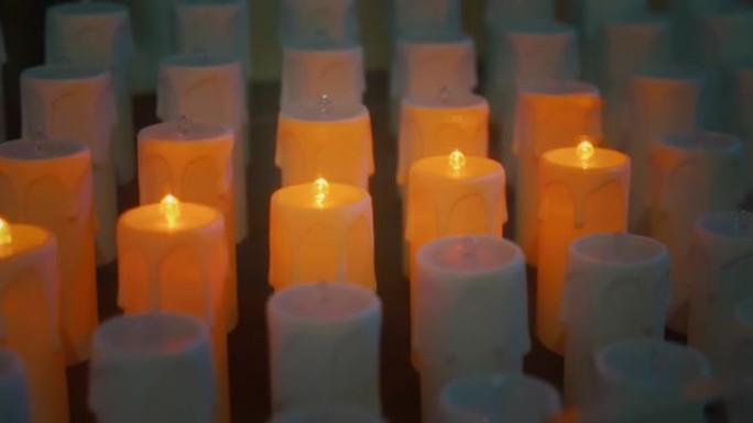 现代天主教教堂里的电蜡烛。人造火焰的金色光芒特写。