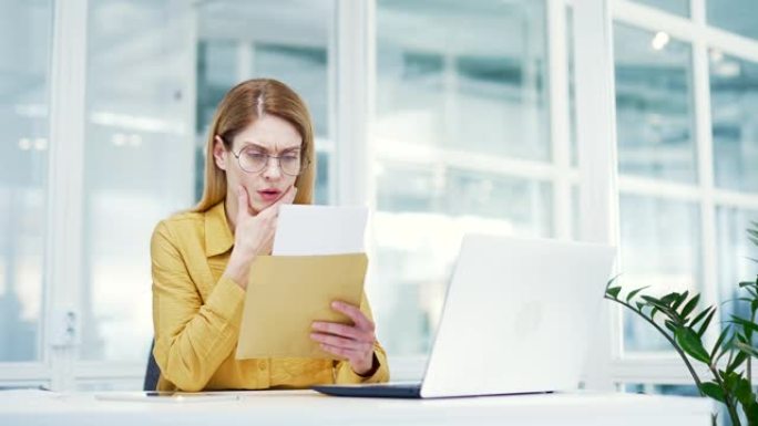 失望的成熟商业女性企业家打开纸信封阅读信与坏消息项目失败或破产在轻办公室