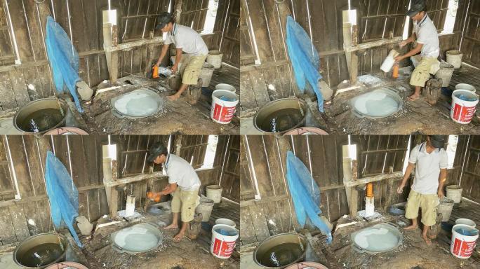 男子准备用蒸煮的热水将米面团切成条状的压力机