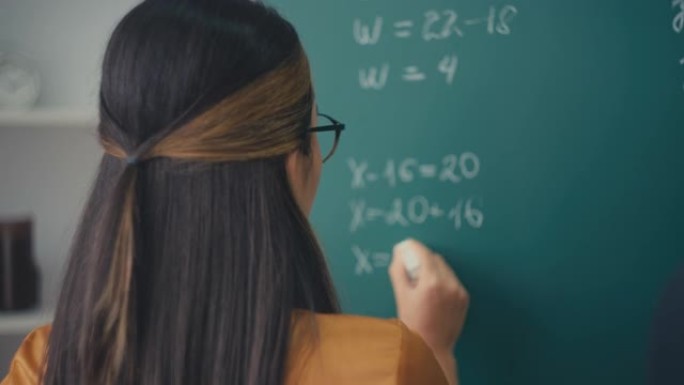 女老师在学校上写数学方程式，教育过程，工作