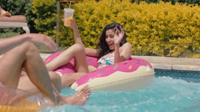 泳池派对有趣的人跳进游泳池，在游泳管上溅朋友，玩得开心，人们在彩色游泳花车上庆祝暑假，享受夏日4k