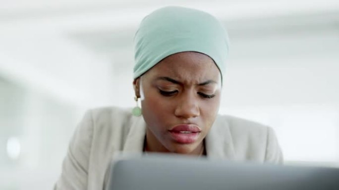 困惑，笔记本电脑和黑人妇女在办公室里读书，同时为公司项目进行研究。烦恼，技术和专业的女性员工在工作场