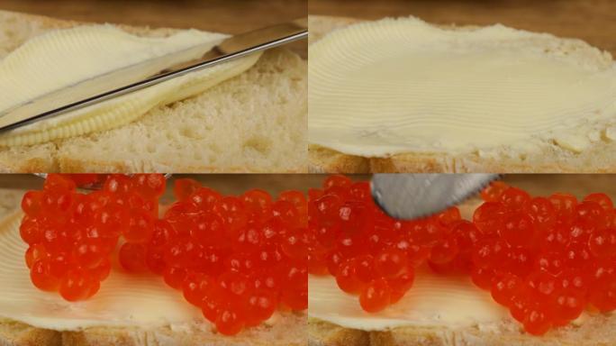 用白面包和黄油和红色鱼子酱在木制切菜板上烹饪三明治。