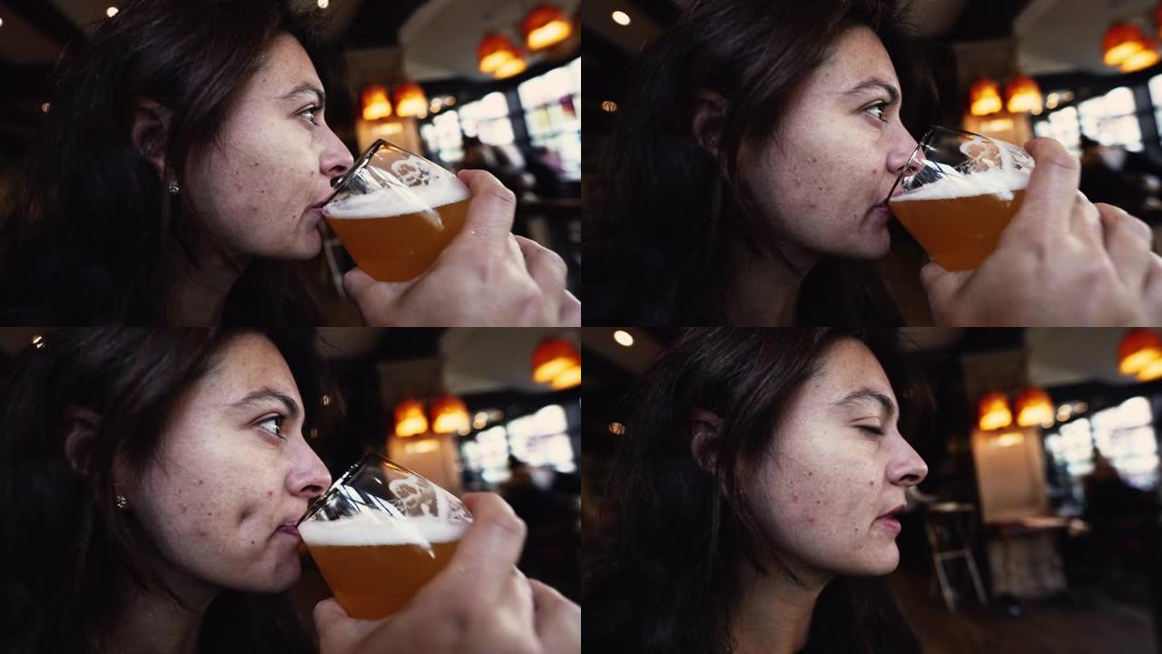 一名女性喝生啤酒。女人在酒吧餐厅喝清爽的大饮料