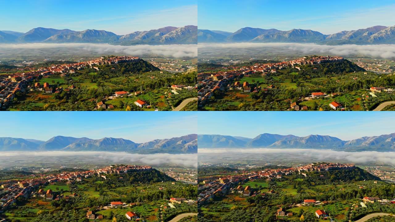 阿特纳·卢卡娜。雾在绿色景观上在镇上的住宅楼上移动。意大利