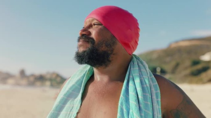 肖像快乐的非洲裔美国男子戴着游泳帽在海滩上享受美丽的海滨早晨准备游泳4k镜头