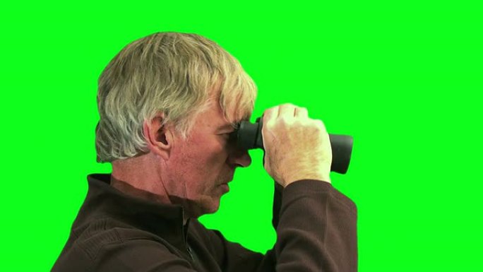 男人透过双筒望远镜对着绿色屏幕-高清