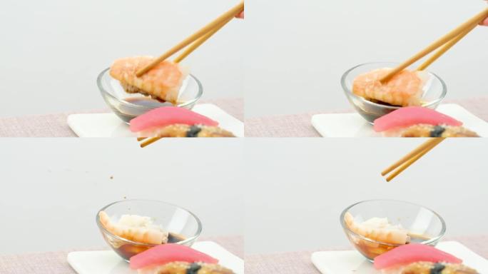 学习如何用筷子蘸寿司失败尝试一块带鱼的米饭掉进盘子里把酱油洒在白色背景上特写初学者学会用筷子吃饭