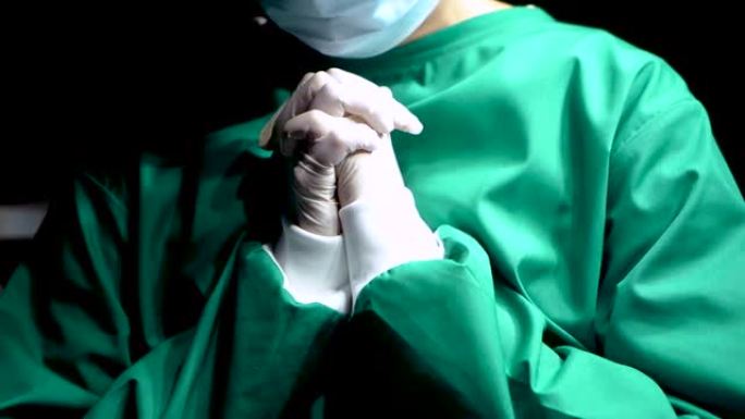 4K，医生的双手特写两旁戴着白色乳胶手套，两只手紧紧地合在一起，为已经停止跳动的患者祈祷奇迹，医生久