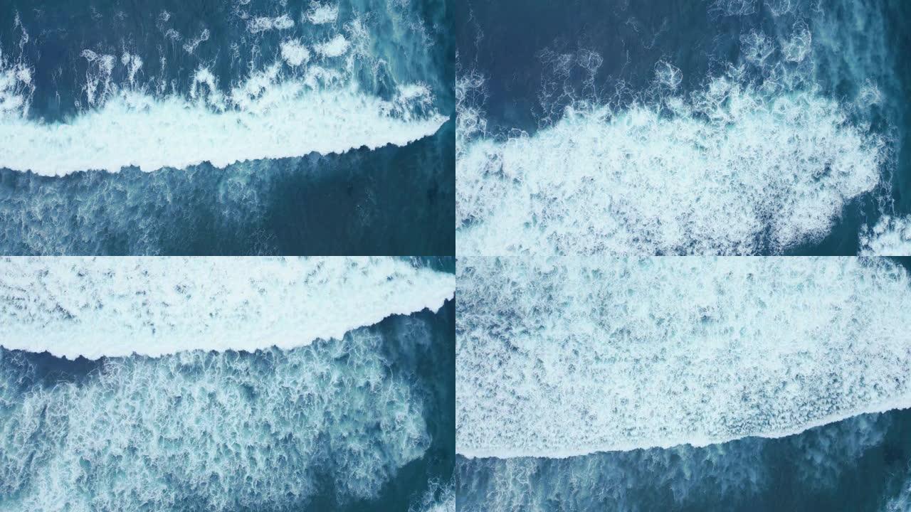 俯视蓝色海洋，有大浪水。空中拍摄美丽的海浪，白色大卷曲。抽象的海洋景观背景。流动高膨胀的电影。高于自