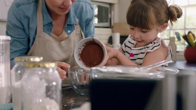 美丽的小女孩帮助妈妈在厨房里烘烤混合配料烘烤巧克力蛋糕在家准备食谱