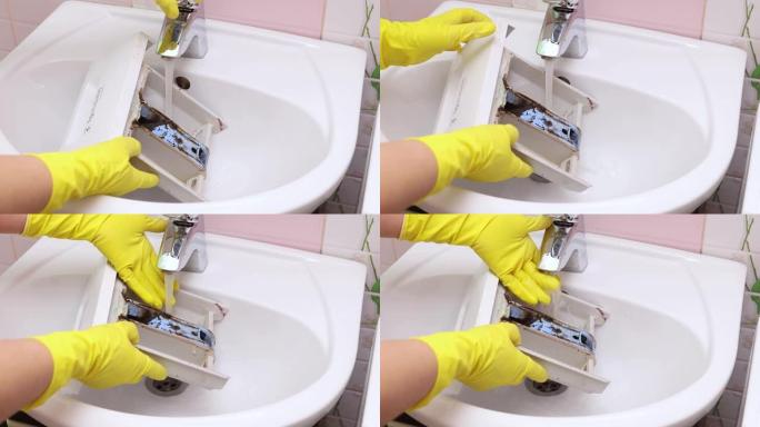 女性用自来水冲洗洗衣机粉末容器。从里面的深色霉菌中清洁容器。