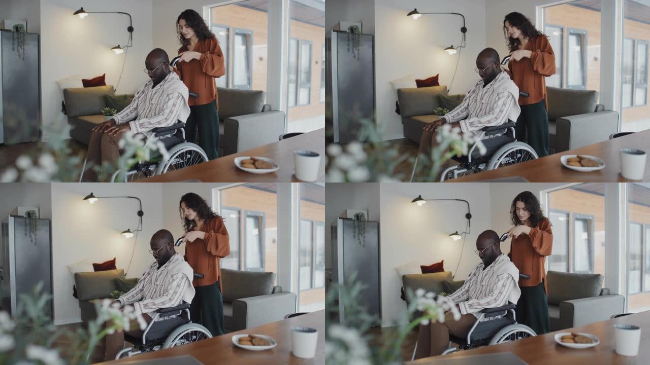 坐在轮椅上的非洲裔美国眼镜男子的白人妇女剃光头