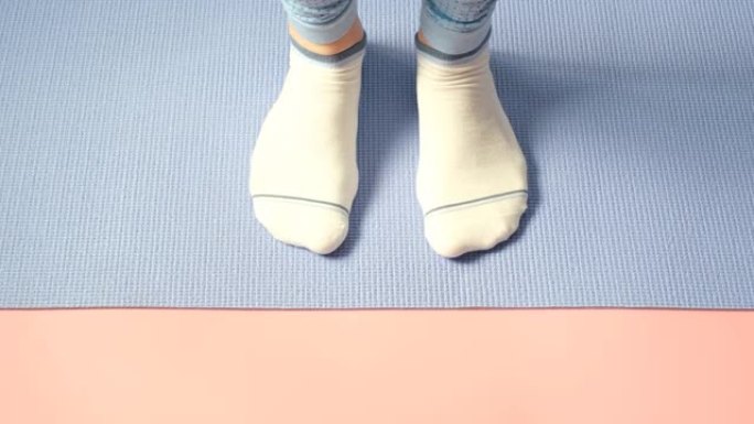 女性腿部在粉红色背景下做脚趾提举练习。