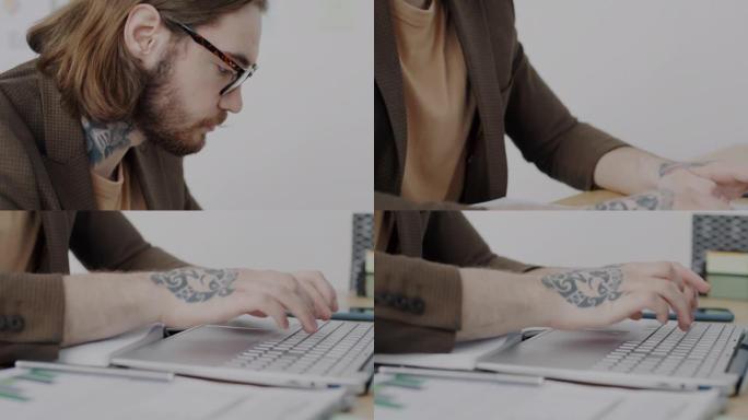 在工作中使用笔记本电脑打字的眼镜和纹身男子的俯仰特写肖像