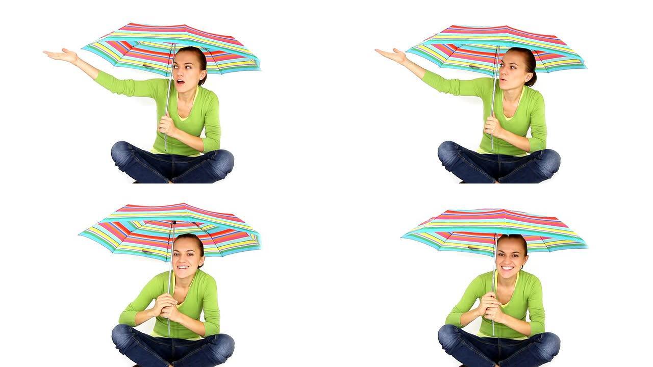 快乐的年轻女子坐着彩色雨伞，孤立在白色上