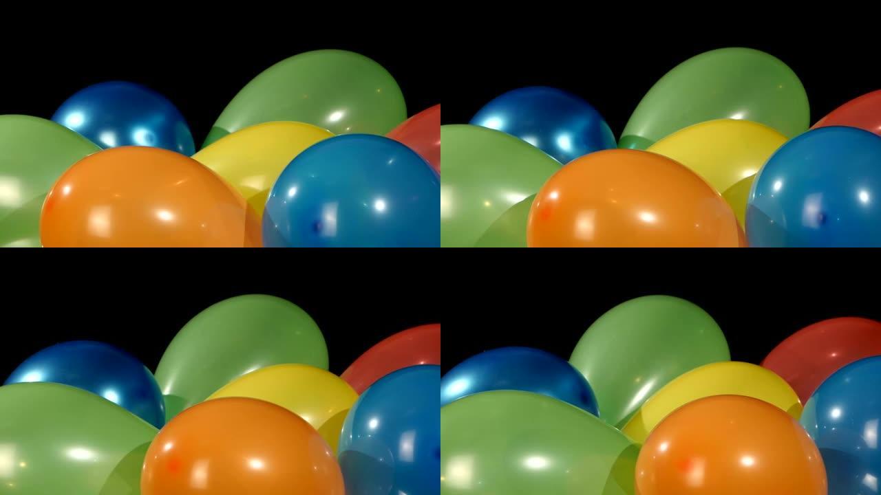 黑色背景上的许多彩色气球，旋转