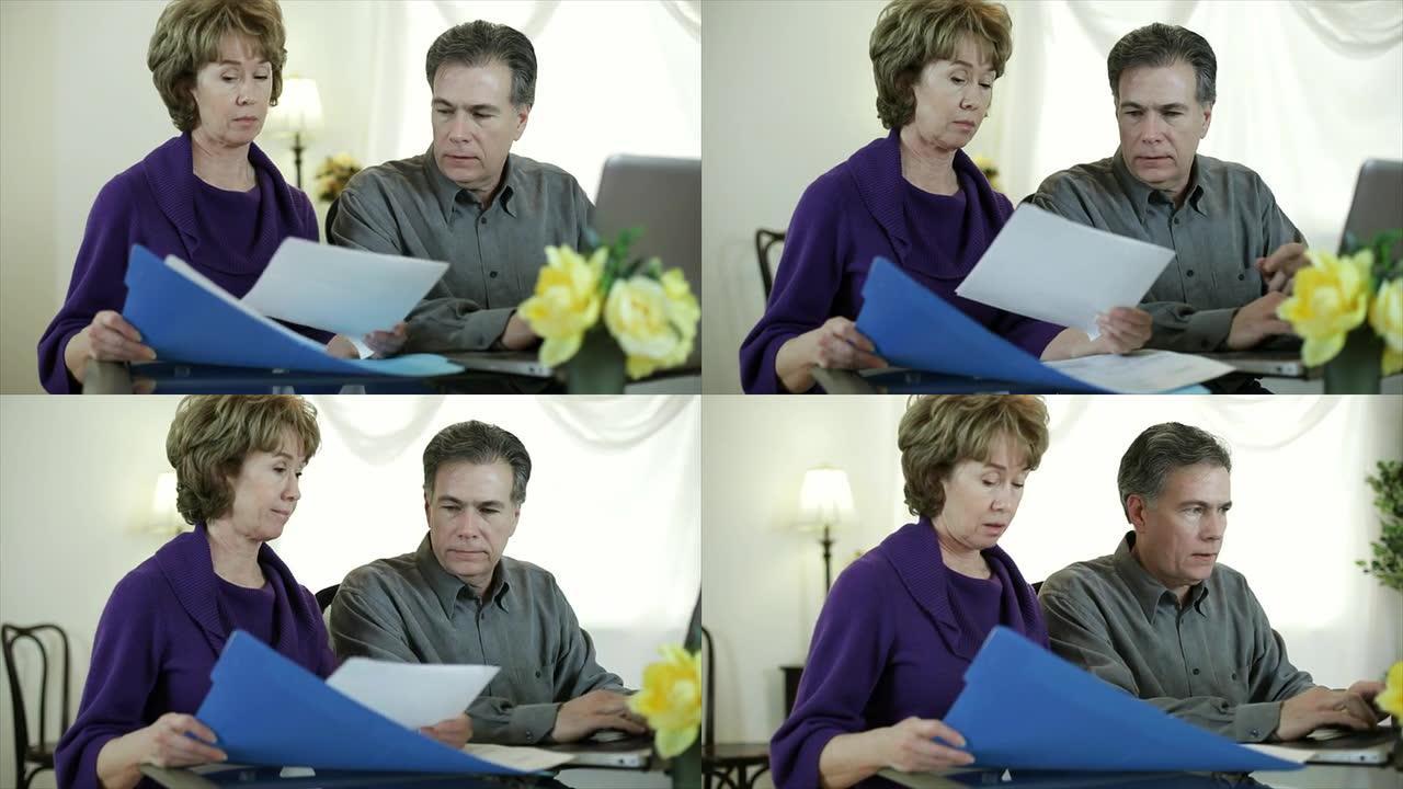 夫妇在笔记本电脑上做账