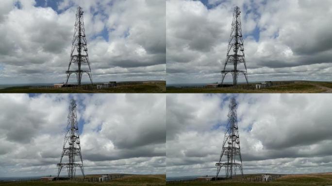 在蓝色多云的天空中站立的现场发射塔的天线