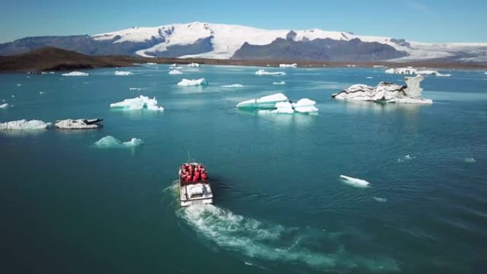 在Jokulsarlon的冰山中航行的两栖船的空中无人机镜头