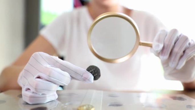 钱币学家在桌子上研究古钱币收藏