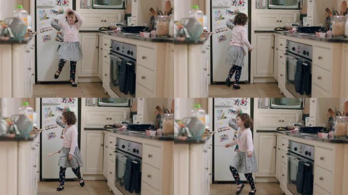 快乐的小女孩在厨房跳舞，玩得开心，在家享受周末的有趣舞蹈动作